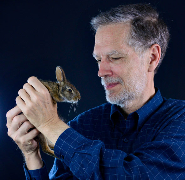 Nicholas Hellmuth holding a wild rabbit of unknown species